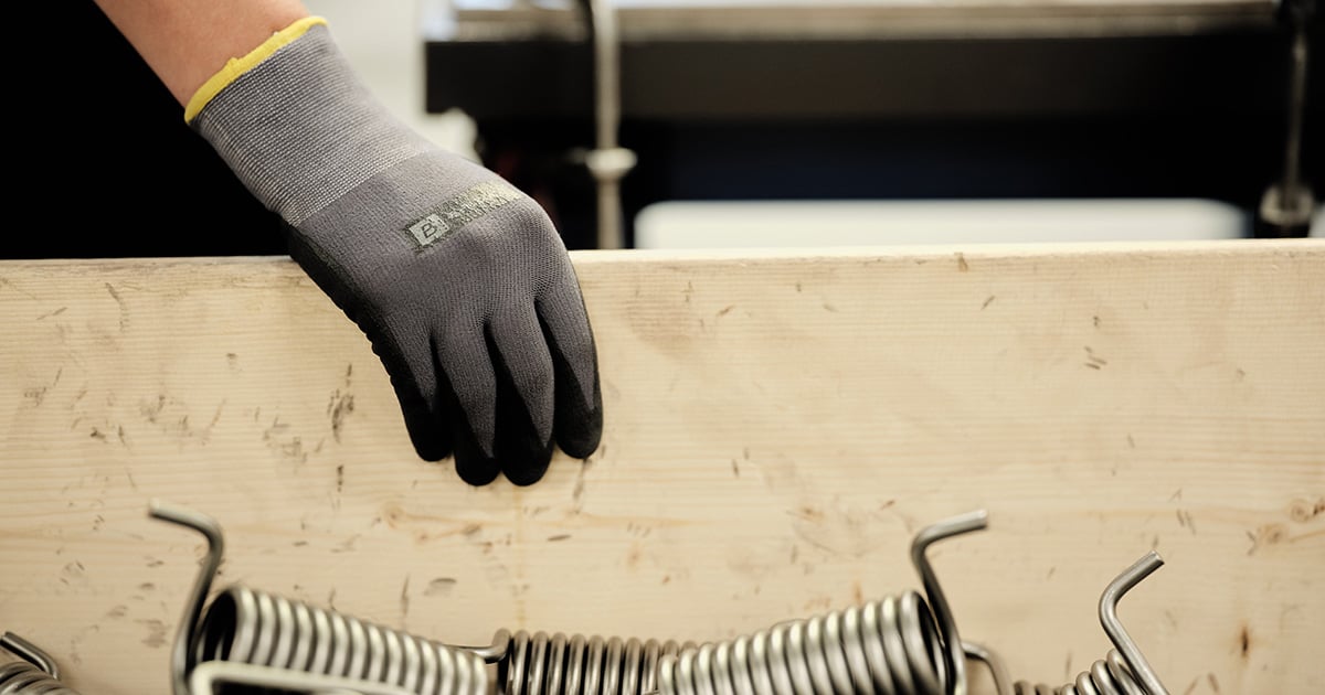 "Een hand rustend op een doos met veren van Lesjofors.